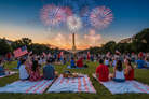 People watching fireworks display with the Washington Monument in the background